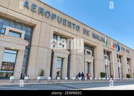 Eine Familiengruppe läuft vor einem Flughafen-Terminal von Malaga unter blauem Himmel, Costa del Sol, Spanien Stockfoto