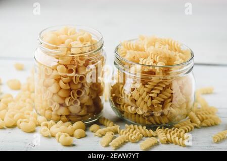 Zwei Arten von italienischen Vollkornnudeln in Gläsern Stockfoto