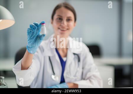 In der medizinischen Klinik hat die Impfung der Bevölkerung gegen covid-19 begonnen, der Arzt zeigt eine Flasche mit dem Impfstoff Stockfoto