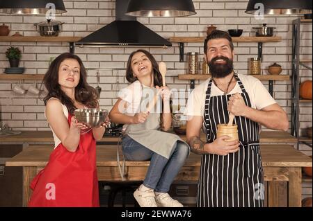 Familie Zeit. Kleines Mädchen mit Mama und Papa in der Küche. Tun Sie alles zusammen. Kochen nach Rezept. Vatertag. Verwandte Spaß beim Kochen. Mutter und Vater lehren Tochter, wie man kocht. Stockfoto