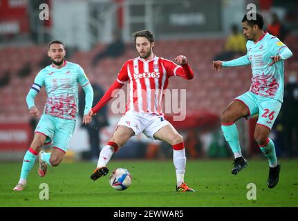 Nick Powell von Stoke City (Mitte) kämpft mit Kyle Naughton (rechts) und Matt Grimes von Swansea City während des Sky Bet Championship-Spiels im bet365 Stadium, Stoke, um den Ball. Bilddatum: Mittwoch, 3. März 2021. Stockfoto