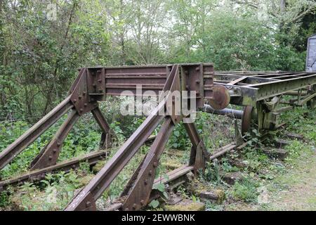 Heritage Eisenbahnlinie Outdoor-Shop mit Puffer, Drehgestell Räder mit und ohne Güterwagen auf kurzen Gleisabschnitt mit großen Bäumen. Stockfoto