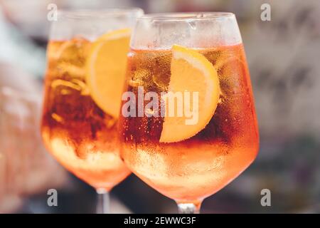 Ein Glas eisgekühlter Aperol Spritz-Cocktail in einem Weinglas serviert, dekoriert mit Orangenscheiben. Aperitif im Straßencafe Stockfoto