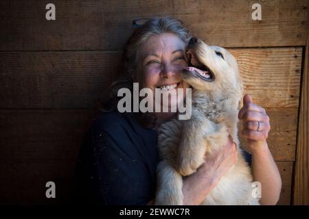 Milton, GA, USA. März 2021, 3rd. Die Gründerin von Canine, Jennifer Arnold, kuschelt sich Mayberry, ein 12 Wochen alter Golden Retriever Welpe, auf ihrer Trainingsfarm in Nord-Georgia AssistantsÃ. "Welpen entwickeln Vertrauen in die Menschen und Vertrauen in sich selbst als Teil unseres Bildungsprotokolls bekannt als Bond-basierte Ansatz", sagte sie. Diese Zukunft Medical Alert Hunde begann die 18-24 Monate Bildungsprozess bei 5 Wochen Alter. Kredit: ZUMA Press, Inc./Alamy Live Nachrichten Stockfoto