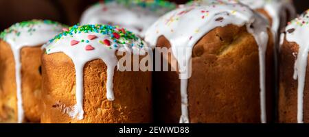 Viele traditionelle Osteuropa russische und ukrainische Osterkuchen kulich mit süßem Zucker Glasur auf Holztisch Morgen Sonnenlicht ray dekoriert. Lecker Stockfoto