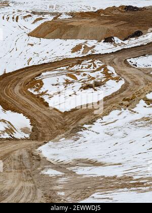 Luftaufnahme des Sandsteinbruchs im Winter, Draufsicht. Hauptstraßen in großen offenen Sandgrube mit weißem Schnee. Stockfoto