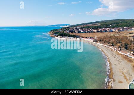 Luftaufnahme der Küste mit Sandstrand und kleinen Gebäuden. Schöne blaue und azurblaue Meereslandschaft von Drohne. Stockfoto