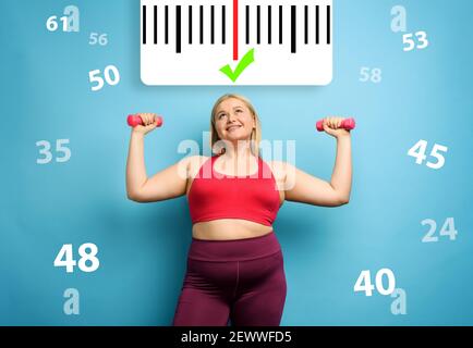 Fat Mädchen tut Fitness-Studio zu Hause mit zufriedenen Ausdruck, weil sie ihr Gewicht zu verringern. Cyanfarbener Hintergrund Stockfoto