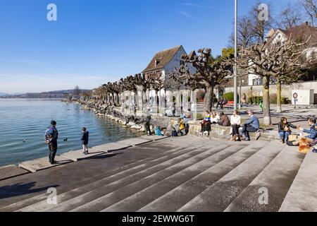 rapperswil jona, sankt gallen, schweiz - 20. februar 2021: Strandpromenade, viele Menschen genießen die warme Sonne am Wasser nach der langen Sperre, Stockfoto