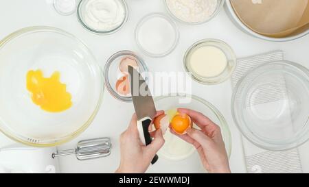 Nahaufnahme Backvorgang. Weibliche Hände trennen Eiweiß von Eigelb. Schritt für Schritt Kuchen Rezept, flach legen Stockfoto