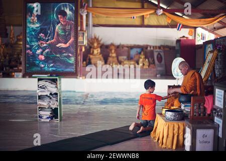 Kleiner Junge, der in einem buddhistischen Tempel in Thailand gesegnet wird. Stockfoto