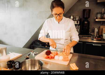 Köchin Schneiden von Gemüse im Restaurant Küche Stockfoto