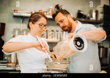 Ein paar Köche arbeiten zusammen, während sie Essen im Restaurant zubereiten Stockfoto