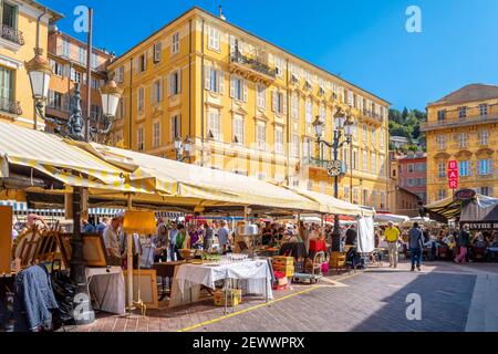 Touristen genießen Sie einen sonnigen Tag am Cours Saleya outdoor Flohmarkt in der mediterranen Stadt Nizza, Frankreich an der französischen Riviera Stockfoto