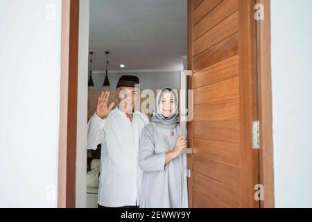 Portrait eines muslimischen asiatischen älteren Ehepaares, das vor der Haustür steht Warten auf Familie zu kommen Stockfoto