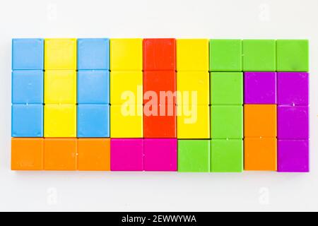 Eine Wand mit bunten Puzzle-Würfel aufeinander gestapelt - geometrische Figuren, Tischspiel Stockfoto