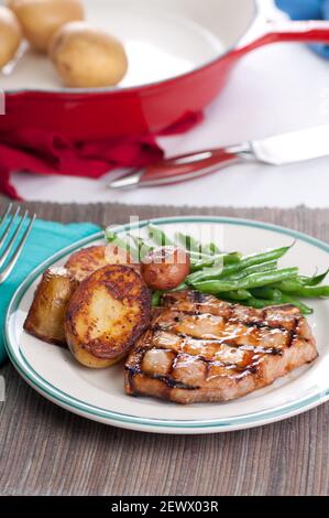 Bio Schweinefleisch mit Pan sautierten Kartoffeln und grüne Bohnen mit einem Pfirsich Sauce chop Stockfoto