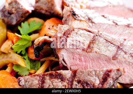 Ribeye gegrillt und mit Stir Fry Gemüse und Nudeln geschnitten Stockfoto