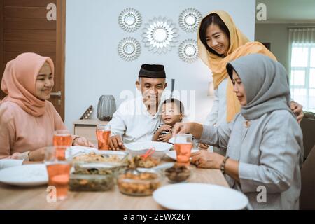 Brechen das Fasten. muslim Asian mit Hijab iftar Abendessen zusammen zu Hause sitzen auf Esstisch Stockfoto