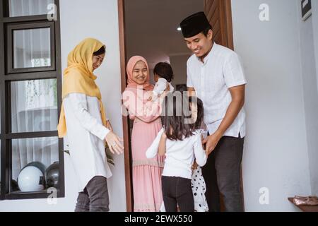 Aufgeregt asiatische muslimische Familie Besuch Freund während eid fitri mubarak Zu Hause Stockfoto