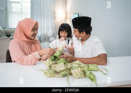 Glücklich asiatische muslimische Familie machen Ketupat zusammen zu Hause vor eid mubarak Stockfoto