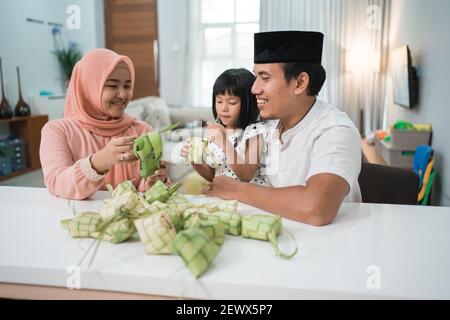Glücklich asiatische muslimische Familie machen Ketupat zusammen zu Hause vor eid mubarak Stockfoto