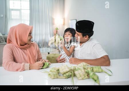 Glücklich asiatische muslimische Familie machen Ketupat zusammen zu Hause vor eid mubarak Stockfoto