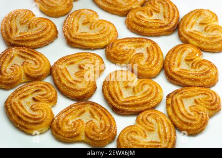 Selektiver Fokus von kleinen herzförmigen Keksen auf weißem Hintergrund. Stockfoto