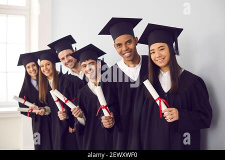 Gruppenportrait von glücklichen multiethnischen Hochschulabsolventen im Besitz Diplome und Lächelnd Stockfoto