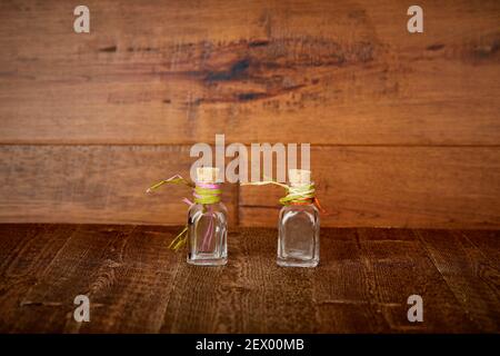Kleine Glas ätherischen Ölflaschen auf mit Korken oben und Farbiges Stroh wickelt die Oberfläche des zurückgewonnenen Holzes ab Stockfoto