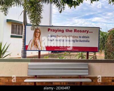 Schild „Beten des Rosenkranzes…“ Der Muttergottes von Fatima in der Nähe der katholischen Kirche des Heiligen Herzens, in der Stadt Childers, Region Bundaberg, Queensland, Austral Stockfoto