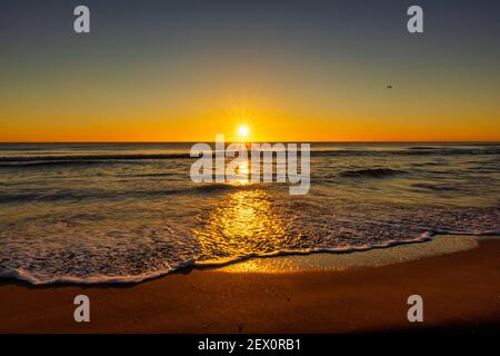 Der Strand bei einem schönen und ruhigen Sonnenaufgang Stockfoto