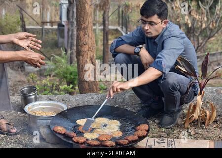 16th. Januar 2021, Pune, Maharashtra, Indien. Mann Braten Lamm Kebabs im Freien in großen Ölkessel Stockfoto