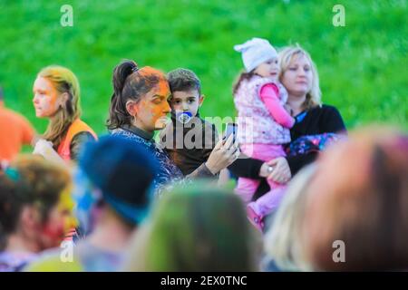 Russland, Moskau - 25. Juni 2017. Fröhliche, junge Menschen werfen sich helle Farben. Fröhliche Gesichter von Erwachsenen und Kindern sind mit Farbe befleckt. Holi Stockfoto