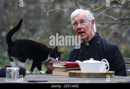 Der Dekan von Canterbury, Reverend Dr. Robert Willis mit Domkatze Lilly, einer von drei schelmischen Katzen, die auf dem 1.400 Jahre alten Sitz der Anbetung in Kent leben, der seine Videogebete ständig stört und zu einem Social-Media-Hit geworden ist. Bilddatum: Dienstag, 2. März 2021. Stockfoto