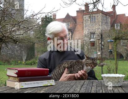 Der Dekan von Canterbury, Reverend Dr. Robert Willis mit Domkatze Tiger, einer von drei schelmischen Katzen, die auf dem 1.400 Jahre alten Sitz der Anbetung in Kent leben, der seine Videogebete ständig stört und zu einem Social-Media-Hit geworden ist. Bilddatum: Dienstag, 2. März 2021. Stockfoto