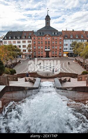Schlossplatz, der Schlossplatz, mit Wasser, das an einem Herbsttag den Brunnen und das alte Rathaus in Pirmasens hinunterläuft. Stockfoto