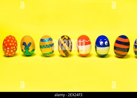 Bunte Ostereier auf gelbem Hintergrund mit Platz für Text. Muster und Designs auf gefärbten Eiern. Stockfoto