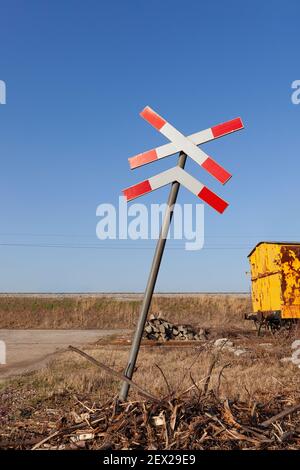 St. Andrews Kreuz mit verlassenen gelben Zug Wagen in der Ferne auf einem alten Gleis Stockfoto