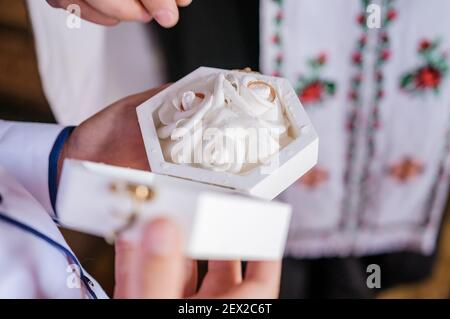 Hochzeit Goldringe in einer weißen Box, Eheringe in Händen Stockfoto