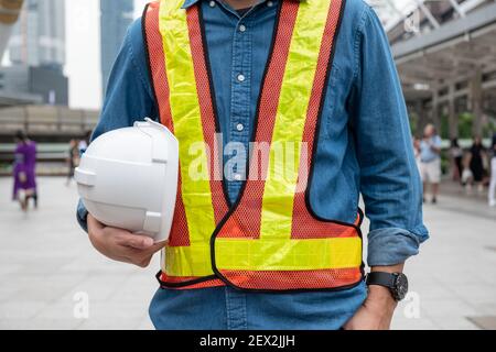 Konstrukteur Mann in der Arbeitsweste hält Sicherheitshelm bei der Konstruktion Standort Stockfoto