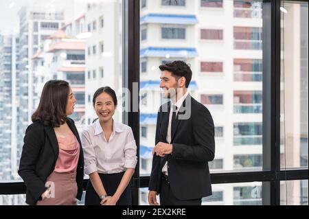 Multiethnische Geschäftsleute mit Kollegen, die sich während eines Meetings unterhalten Im Büro Stockfoto