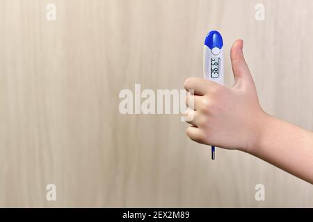 Hand mit einem Thermometer. Daumen hoch. Die Temperatur ist in Ordnung. Stockfoto