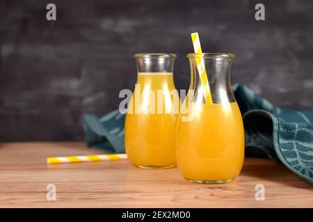 Hausgemachte Limonade aus Zitrusfrüchten in kleinen Flaschengläsern Mit Trinkhalmen Stockfoto