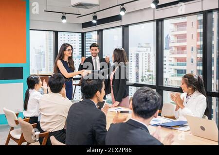 Multi ethnische Geschäftsfrau schüttelt Hände Zusammenarbeit für Corporate Agreement mit Mitarbeiter im modernen Büro Stockfoto