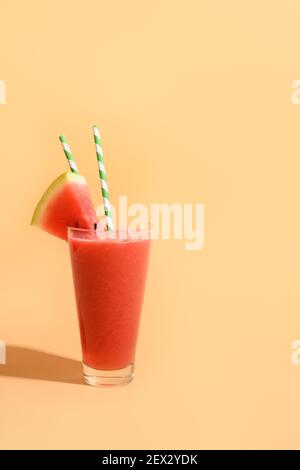 Erfrischender kalter Sommerdrink Wassermelone Slushie garnieren Minze mit Schatten auf Beige. Stockfoto