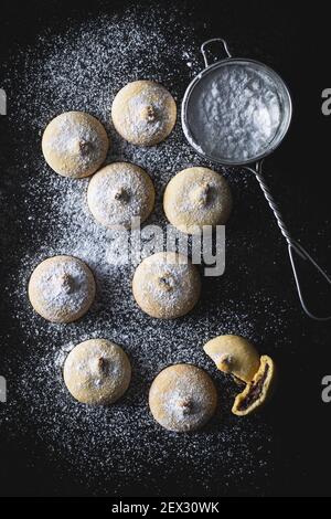 Kekse mit Schokoladencreme. Süße Kekse auf schwarzem Tisch. Draufsicht. Stockfoto