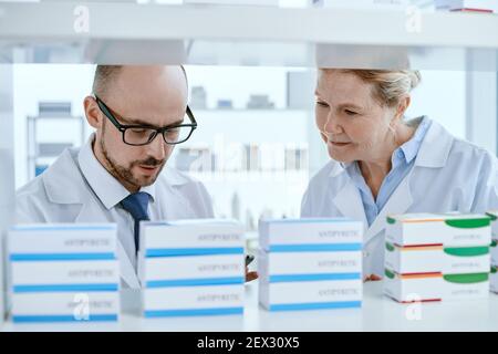 Der leitende Apotheker und sein Assistent suchen nach wichtigen medizinischen Hilfsgütern. Stockfoto