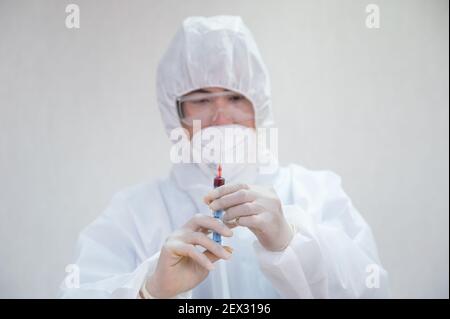 Asiatische männliche Arzt in medizinischen psa hält Spritze Injektion Blut Probe im Labor Stockfoto