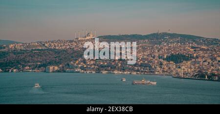 Istanbul, Türkei - 2. Februar 2021 - Panorama-Sonnenuntergangsansicht der Fähren auf der Bosporus-Meerenge mit dem Gebiet von Uskedar auf der asiatischen Seite Stockfoto